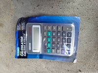 Photo of brand new Estudio Solar calculator in original plastic and cardboard packaging showing keypad and solar panel.
