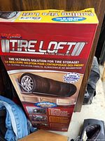 Original boxed packaging of the HyLoft Tire Loft multi-tire storage rack, showing branding, product image, and features.