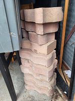 Vertical stack of decorative concrete bricks with curved edges.