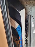 Photo of five hockey sticks leaning in a narrow space showing various brands and colors including Easton and Warrior Covert.