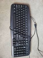 Top-down photo of black wired USB keyboard showing full QWERTY layout and numeric keypad.
