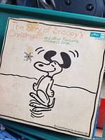 Front cover of 'The Story of Snoopy's Christmas' vinyl record showing Snoopy ice skating artwork and title text.