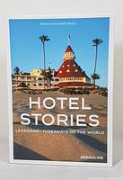 Front cover of 'Hotel Stories - Legendary Hideaways of the World' hardcover book showing the Hotel del Coronado with palm trees and blue sky.