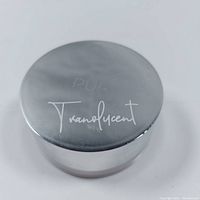Round jar of translucent loose setting powder with metallic silver lid featuring PÜR branding and "Translucent" text.