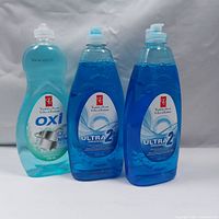 Three bottles of dishwashing liquid: one OXI Fresh Scent 739 ml and two ULTRA 2X Original 638 ml bottles