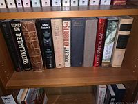 Shelf view showing a collection of hardcover books including Stephen King, Thomas Harris, Shakespeare complete works, and others.