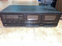 Front view of black JVC TD-W103 stereo double cassette deck showing dual cassette compartments and control buttons.