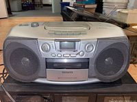 Front view photo of the Aiwa CD stereo radio cassette recorder showing dual speakers, display, control buttons, cassette deck, and top CD player lid.