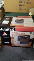Photo of the Holmes Warm Mist Humidifier in its original box showing the full packaging and product image on the box.