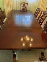 Full top view of rectangular cherrywood dining table showing polished surface and chairs around it.