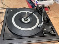 Photo of the turntable platter, tonearm, and control switches showing the overall condition and design.