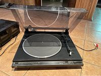 Front view of the JVC turntable showing dust cover, platter, tonearm and base.