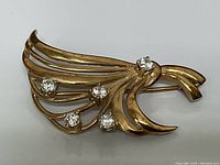 Front view of brooch showing ribbon design and all five diamonds