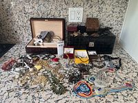 Overview of all jewelry items and two jewelry boxes on granite countertop