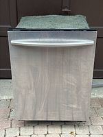 Front view of stainless steel Samsung dishwasher with horizontal handle, showing minor surface wear.