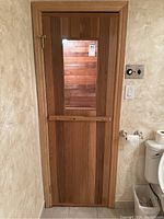 Exterior view of cedar sauna door with glass panel