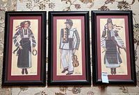 Three framed prints arranged side by side on patterned surface