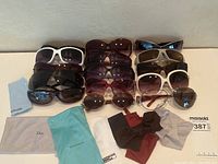 Overview of 11 sunglasses and 6 microfiber cloths on white surface