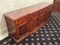 Angled front view showing entire sideboard with three drawers and four cabinet doors