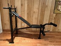Side view of the Weider workout bench showing the adjustable backrest and leg curl/extension attachment with padded rollers.