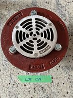 Front view showing the stainless steel strainer with vented slots and three bolts, cast iron base with embossing.