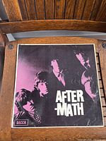 Front cover of 'Aftermath' album showing band photo with purple tint and Decca branding.