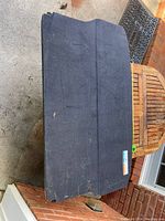 Full view of the black rear cargo cover plate showing overall used condition with scuffs and scratches.