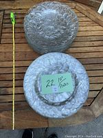 Top view of stacked clear glass plates approximately 10 inches in diameter with a visible textured leaf pattern. Includes a tape measure for scale and a paper note indicating "22 - 10\" Plates".