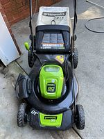 Front view of mower showing 22-inch deck, wheels, handle, and installed battery