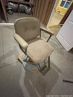 Adjustable hair stylist chair showing cushioned seat and back with metal base needing deep cleaning