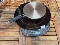 Induction cooktop with conversion plate on top showing details of the device and handle