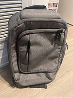 Front view of grey Targus backpack showing main compartments and zipper pullers