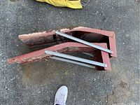 Top view of two red metal car ramps showing wear and metal support braces