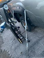 Easy bar leaning against a vehicle, showing full length and shape including the grips and ends.