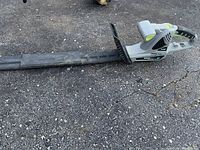 Full view of electric hedge trimmer with blade cover on, showing handle, blade cover, and overall length of trimmer.