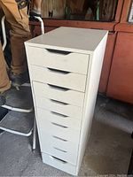 Full view of the white IKEA drawer unit, showing all nine drawers stacked vertically.