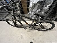 Photo showing left side view of Norco Katmandu mountain bike with front suspension and disc brakes, black and orange paint.