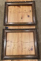 Two antique wooden picture frames laid flat side by side displaying the ornamental plaster designs and aging finish