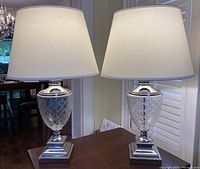 Both lamps side by side on wooden surface under ambient light