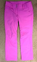 Front view of pink Descente Selene women's ski pants, showing slim fit, button and zipper front, belt loops, and pockets.