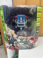 Front view of Johnny Lightning Transformer HumVe RC toy inside original box, showing try-me button and packaging graphics.