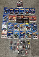 Full lot of Hot Wheels Camaro diecast cars carded and loose arranged on floor, showing different series and packaging styles