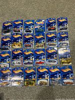 Full lot of 24 carded Hot Wheels trucks laid out on carpet