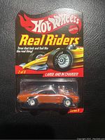 Front view of Hot Wheels Real Riders Series 9 car in blister packaging labeled 'Large and in Charger'