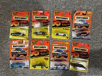 Overview of 8 Mid-90s Matchbox cars on original orange-yellow Super Fast cards. Cars include Camaros, trucks, and a Firebird Racer.