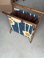 Three-quarter view of the knitting or crochet bag stand showing the wooden frame with patterned fabric bag attached.
