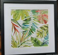 Front photo of a square watercolor painting of tropical leaves in a black frame with white matting.