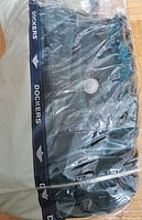 Gray and navy blue Dockers branded carrying bag for the inflatable bed inside a plastic cover.