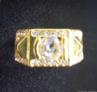Top view of ring on black background showing central stone and surrounding accent stones