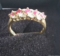 Front view of ring showing alternating red and clear stones